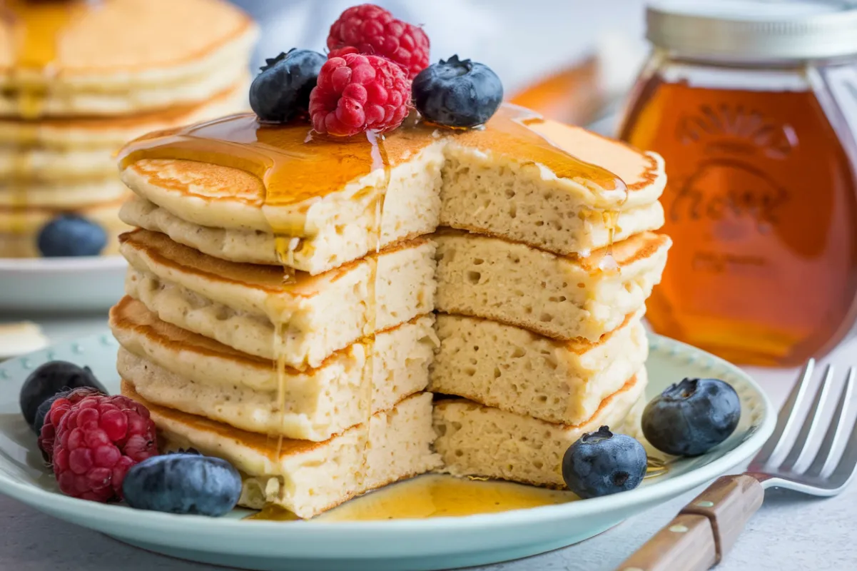 Cottage cheese pancakes topped with fresh berries and honey drizzle